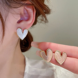 Detail of sweet heart-shaped stud earrings with marble texture enamel and gold trim