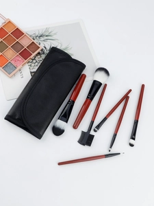 Detail of 7-piece makeup brush set with mahogany handles in a black leather roll-up case