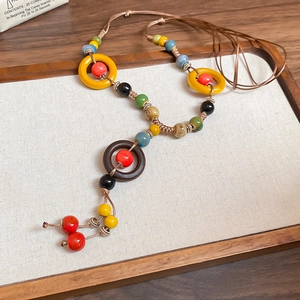 Detailed view of bohemian ethnic necklace featuring multi-colored ceramic beads and woven cord