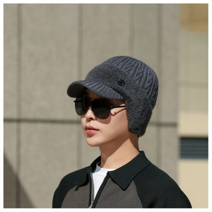 Detailed view of dark grey knitted ear flap hat with textured weave and soft plush lining