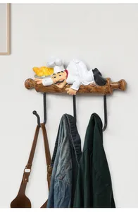 Nordic resin chef wall rack with three metal hooks holding a jacket and a bag