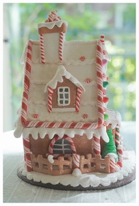 Close-up of a glowing gingerbread house with sugar frosting and candy cane decorations