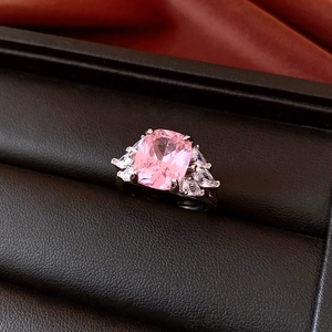 Detailed macro view of a pink zircon ring with marquise side stones in a jewelry box