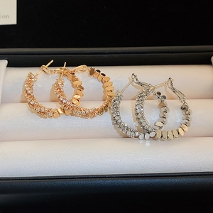 Close-up of gold and silver hoop earrings with pave cubic zirconia in a jewelry box