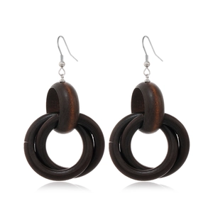 Detail of dark brown layered wooden hoop earrings with silver hooks on white background