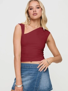 Détail d'un haut Y2K bordeaux asymétrique porté avec une jupe en jean sur mannequin