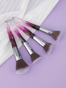 Detailed macro view of four professional makeup brushes with purple gradient crystal handles