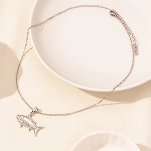 Detail shot of a fish-shaped stainless steel pendant with textured sea pattern and O-chain