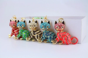 Close-up of five rhinestone-studded lucky cat charms in red, gold, blue, green, and pink