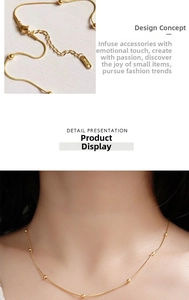 Detailed shot of 18K gold-plated snake chain with beads and lobster clasp on neck