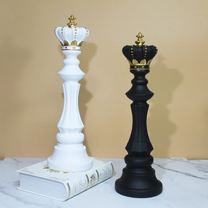 Nordic resin chess sculptures in black and white with gold accents on marble