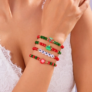 Dettaglio di un set di 4 braccialetti natalizi con perline e ciondoli al polso