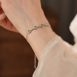 Detail of round green zircon bracelet with white crystal halo on silver adjustable chain