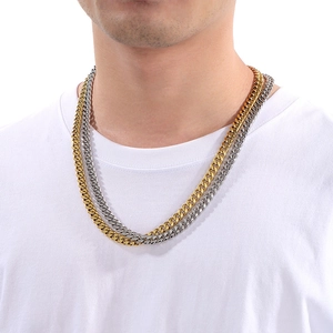 Close-up of gold and silver stainless steel Cuban link necklaces on a male model