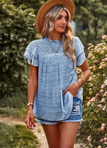 Detail of blue leopard print top featuring ruffle sleeves and elegant round neckline