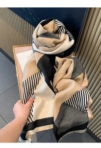 Detail of soft cashmere-feel scarf featuring geometric patterns and fringe tassels