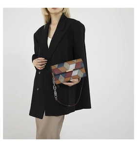 Detail of multi-color patchwork leather bag with golden bar lock and chain strap