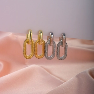 Fashionable gold and silver oval hoop earrings with shimmering textured pave details