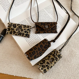 Macro shot of mini leopard print leather pendants and coin purses on an open book