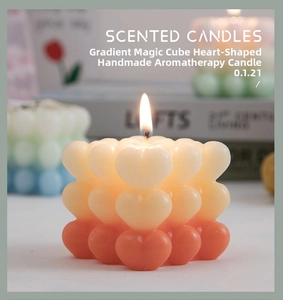 Macro shot of gradient heart-shaped rubiks cube scented candle with warm orange tones