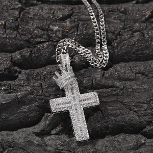 Detail of silver crown cross pendant with sparkling zircons on a dark wood background