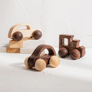 Macro detail of natural walnut wood toy cars and locomotive with smooth grain finish