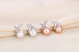 Macro shot of S925 silver cross line earrings with white and pink freshwater pearls