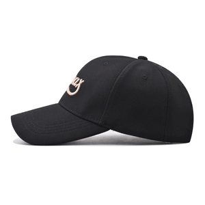 Detail view of Smiley embroidery on a black canvas baseball cap with curved brim