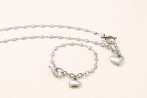 Close-up of silver stainless steel heart necklace and bracelet set with T-bar toggle clasp