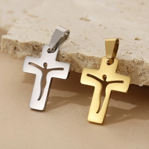 Macro shot of gold and silver hollowed-out cross pendants with Jesus silhouette