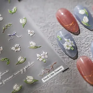 5D embossed nail art stickers with white tulips and floral designs on light blue nails