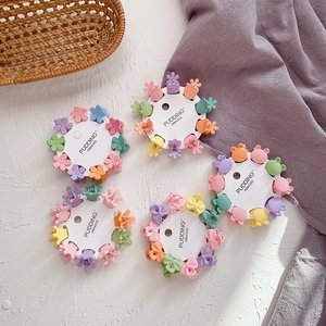 Set of colorful mini resin hair claws in flower and bear shapes on white display cards