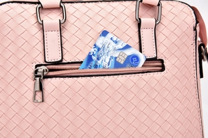 Detailed back view of pink woven handbag featuring functional zipper pocket and card slot