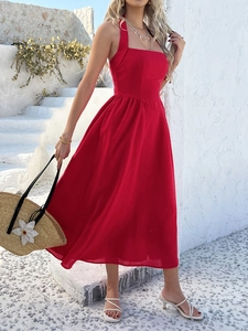 Detailed back view of a red halter neck maxi dress against white Mediterranean steps