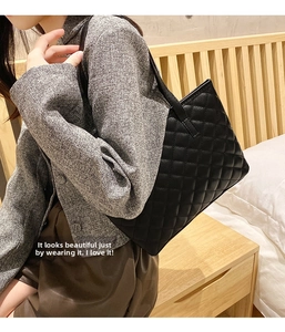 Detail of a black quilted tote bag with diamond stitching pattern on a female model