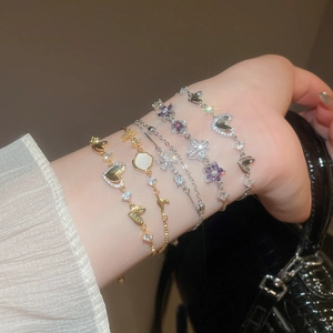 Detailed view of elegant bracelets with purple butterflies, hearts and sparkling zircons