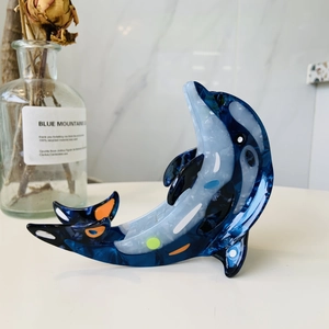 Detail of dolphin hair claw clip made of blue marble pattern acetate with smooth texture
