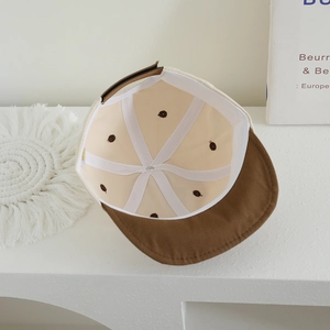 Interior view of polka dot baby baseball cap showing soft lining and stitch details