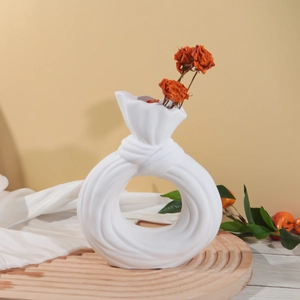 Jarrón moderno de cerámica blanca en forma de nudo con diseño hueco y flores secas