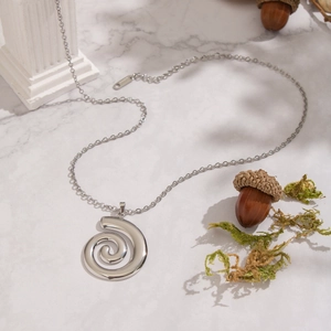 Vue détaillée du collier pendentif spirale argenté montrant le poinçon S925 sur l'acier poli