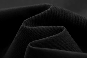 Macro shot of high-density black twill fabric texture on sleeveless vest jacket
