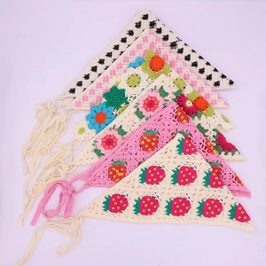 Detailed view of assorted handmade crochet daisy and strawberry knit triangle bandanas
