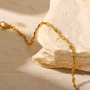 Détail d'un bracelet en acier inoxydable plaqué or 18K avec maillons ovales sur pierre
