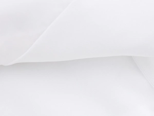 Close-up of white fabric texture showing detailed weaving and soft pleats of the set