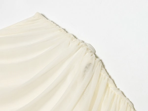 Detail shot of the layered cream mesh fabric with pleated texture and elastic stitching