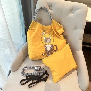 Close-up of yellow nylon cat embroidery tote bag with woven strap and pouch set