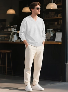 Close-up of men's white V-neck knit sweater featuring classic cable patterns and ribbed cuffs