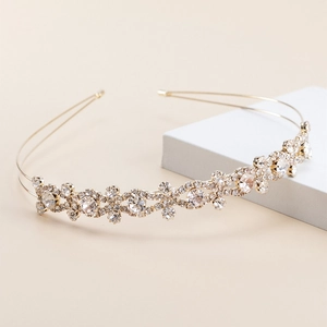 Detailed close-up of a gold metal headband featuring sparkling rhinestone embellishments