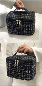 Detail of tweed makeup bag with black faux leather handle and gold dual zipper closures