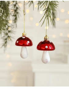 Red and white mushroom Christmas ornament hanging on a pine branch with warm bokeh light